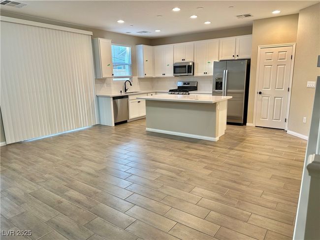 Kitchen featuring a sink, white cabinets, light countertops, appliances with stainless steel finishes, and backsplash | Image 18