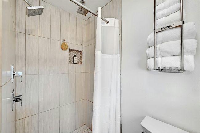 The primary bedroom includes an alluring walk-in shower with multiple showerheads. | Image 20
