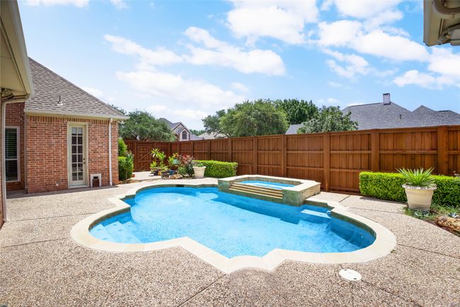 View of pool featuring a fenced backyard, a patio area, and a pool with connected hot tub | Image 30