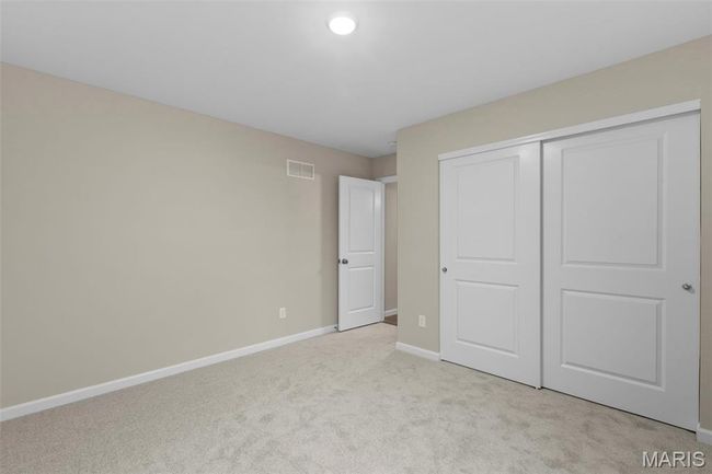 Unfurnished bedroom with light colored carpet, baseboards, and a closet | Image 12