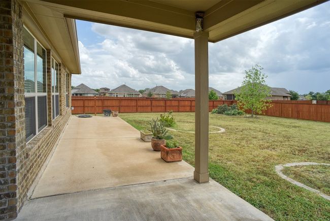 Fenced backyard with a patio area | Image 27