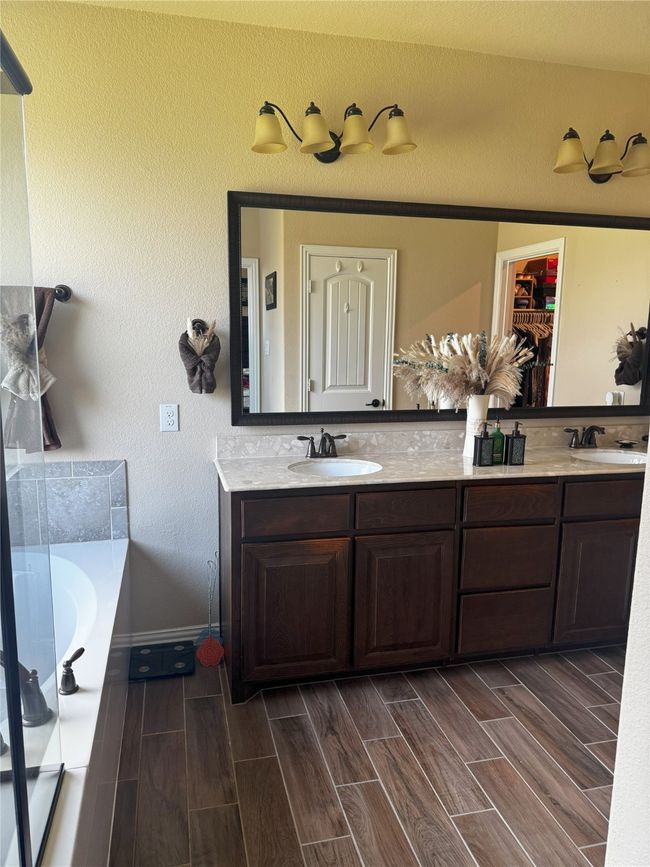 Master bathroom featuring double vanity, a garden tub, and wood finish floors | Image 9