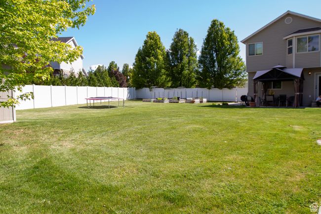 View of yard with a trampoline and raised garden beds | Image 31