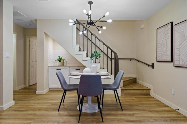 Dining room featuring light wood-style flooring, baseboards, a notable chandelier, and stairs | Image 16