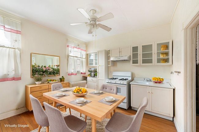 Kitchen with under cabinet range hood, glass insert cabinets, light wood-style floors, and gas range gas stove | Image 11