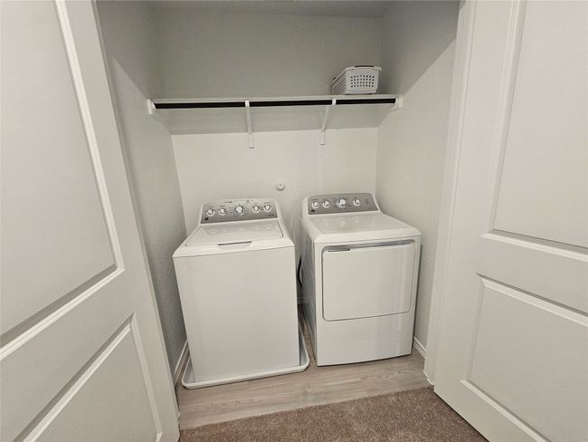 Laundry room with light wood-style floors, washing machine and clothes dryer, and laundry area | Image 28