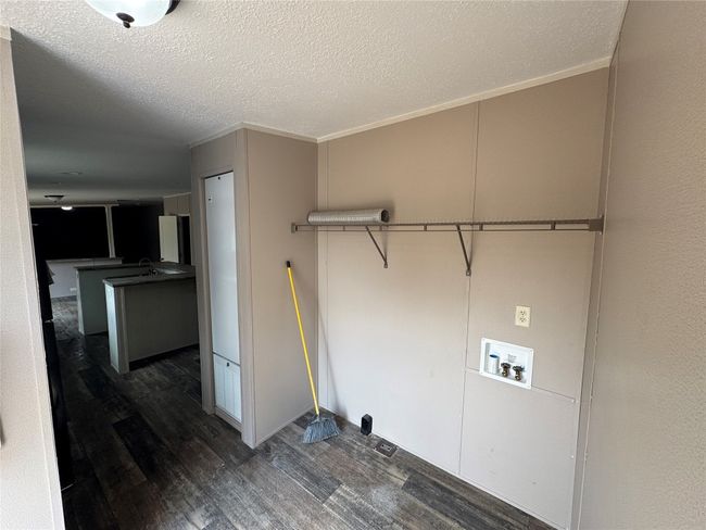 Laundry area with dark wood finished floors, laundry area, ornamental molding, washer hookup, and a textured ceiling | Image 9