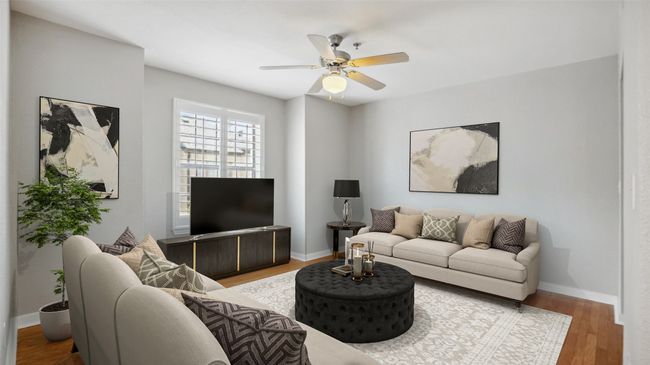 Living area with a ceiling fan, wood finished floors, and baseboards | Image 9