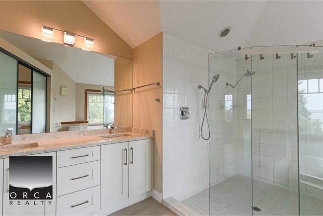 Full bath featuring a shower stall, double vanity, and lofted ceiling | Image 23