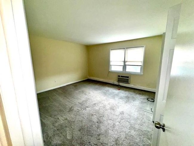 Spare room featuring carpet, a wall mounted AC, and baseboards | Image 6