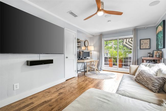 Living area with crown molding, wood finished floors, a desk, and ceiling fan | Image 28