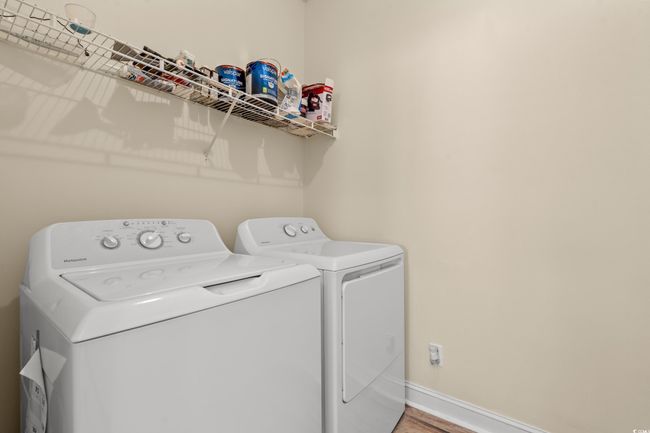 Washroom with baseboards, washer and dryer, wood finished floors, and laundry area | Image 10