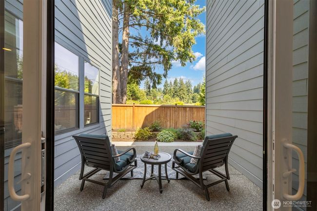 Directly off the formal dining room, this second patio offers a peaceful escape for after-dinner drinks or quiet morning coffee. Framed by lush landscaping and mature evergreens, it's a private retreat that seamlessly extends the living space outdoors. | Image 21