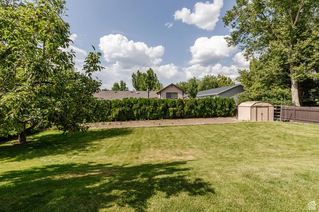 Fenced backyard featuring a storage shed | Image 35