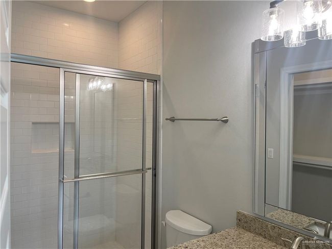 Full bathroom featuring toilet, a shower stall, and vanity | Image 7