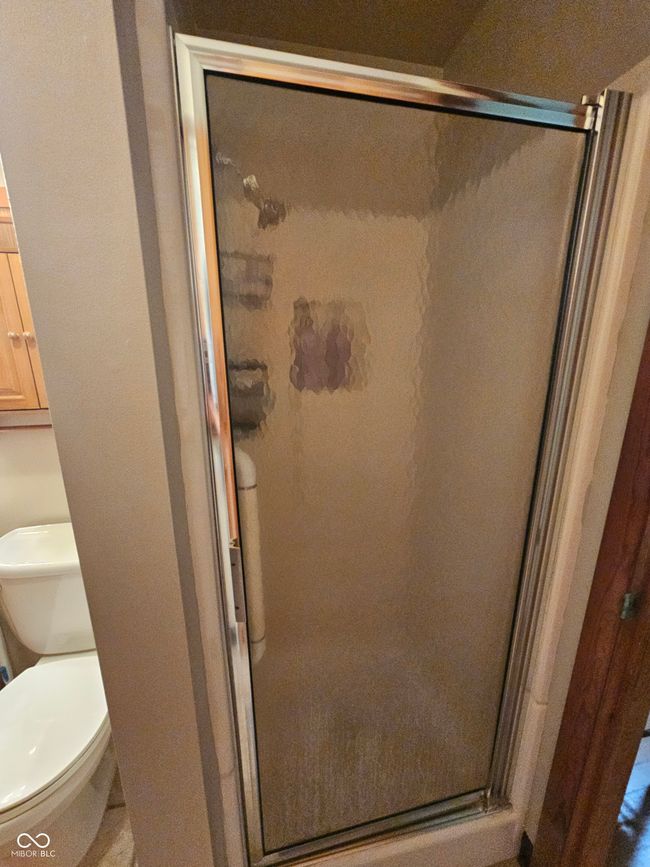 bathroom with a shower stall and toilet | Image 24