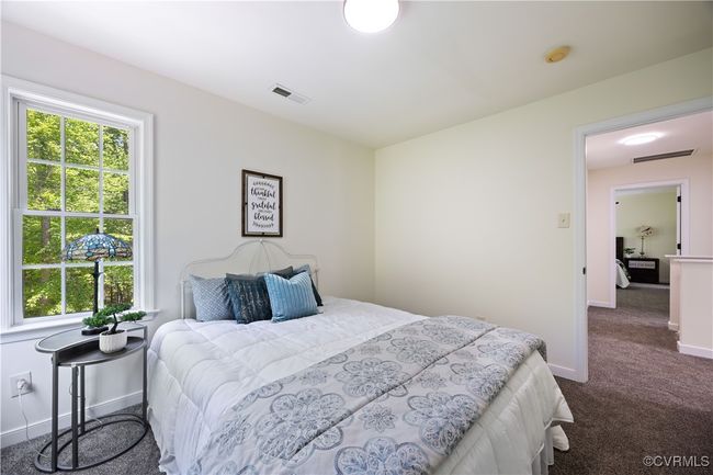 Bedroom with dark colored carpet, multiple windows, and visible vents | Image 28