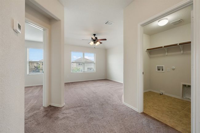Laundry room featuring gas dryer hookup, hookup for a washing machine, carpet floors, ceiling fan, and baseboards | Image 22