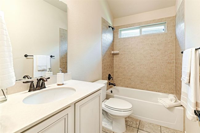 Bathroom with vanity, bathtub / shower combination, and tile patterned floors | Image 19