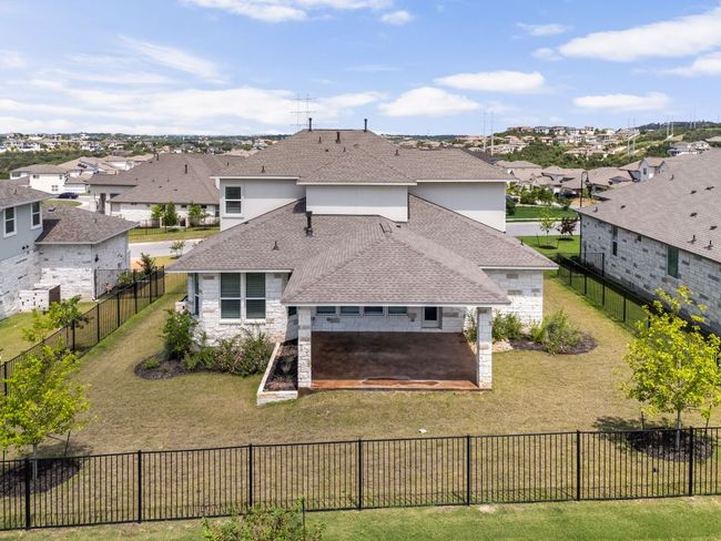 Rear view of property featuring roof with shingles, a residential view, stone siding, a patio area, and stucco siding | Image 38