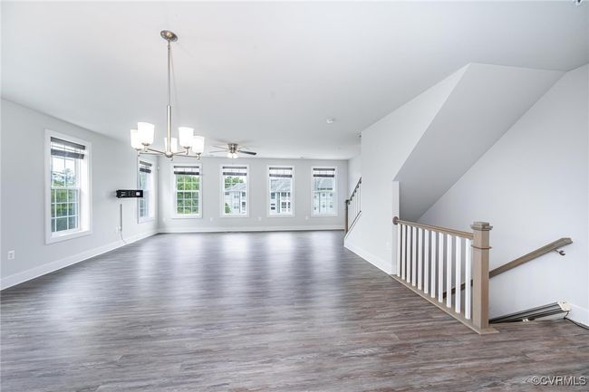 living room with a chandelier and wood finished floors | Image 5