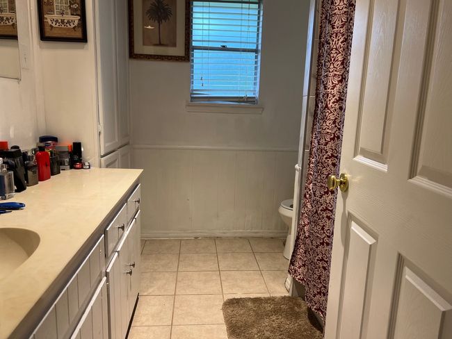 Full bath featuring toilet, vanity, a wainscoted wall, and tile patterned flooring | Image 12