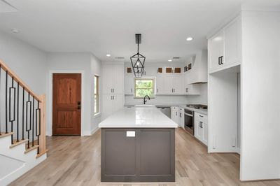 Upon entering, you will find the expansive 16'9"x13'9" kitchen to your left. An extremely well designed space, it offers two windows for natural light, high-end stainless steel appliances and solid white oak flooring! | Image 3