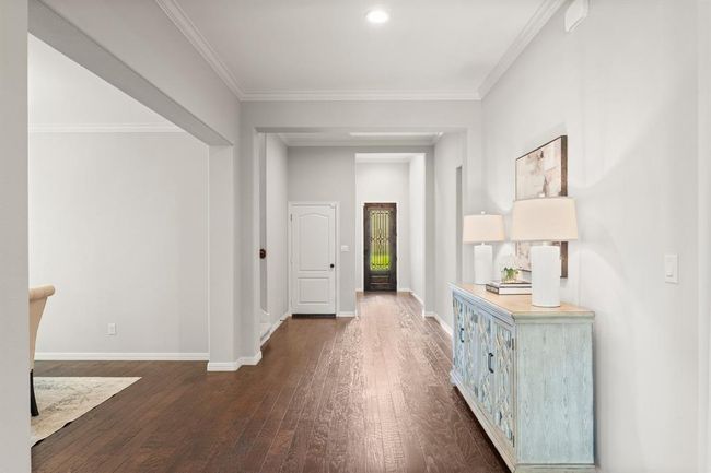 View from the main living area showcasing the wide entry, crown molding, and elegant wrought iron leaded glass front door | Image 6