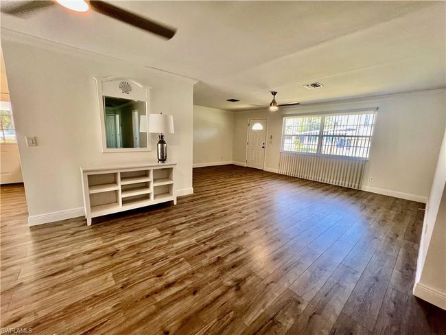 Living room featuring crown molding, LUXURY VINYL PLANK FLOORS. | Image 19
