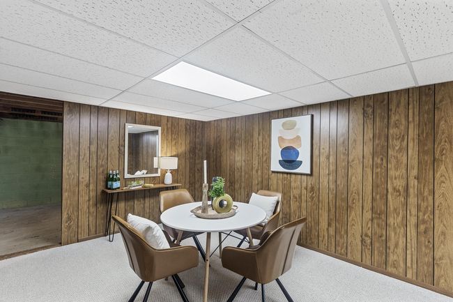 The west side of the rec room provides the perfect spot for additional seating or a cozy game night. Access a large storage space just past this area which wraps around into the laundry area. | Image 8