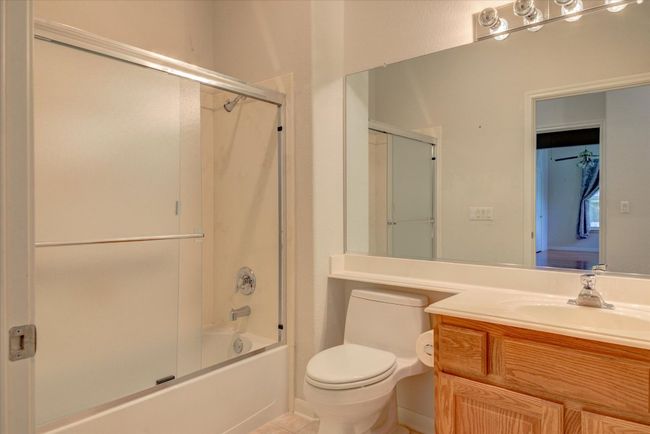 Full bath featuring vanity, enclosed tub / shower combo, and tile patterned flooring | Image 24