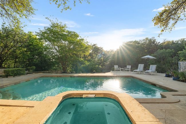 View of pool with a patio area and a pool with connected hot tub | Image 36