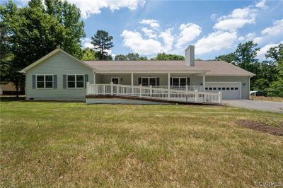 Ranch-style home featuring a porch, a garage, and a front lawn | Image 1