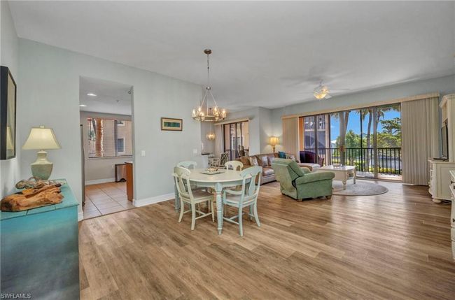 Dining room featuring a ceiling fan, light wood-style flooring, and a chandelier | Image 6
