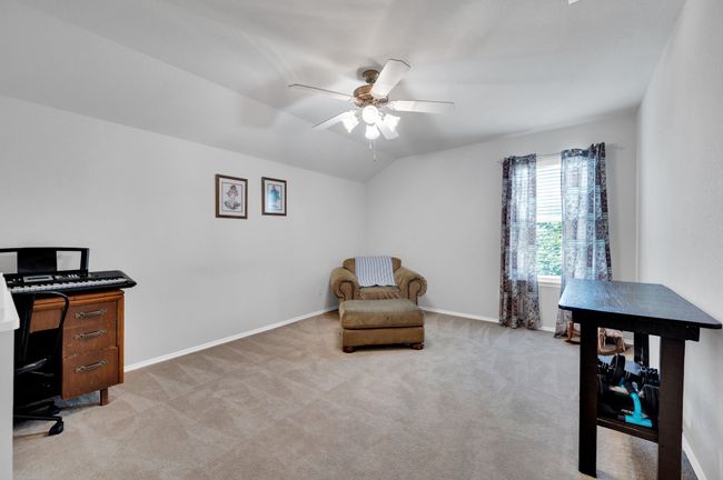 Bedroom featuring ceiling fan, light carpet, and vaulted ceiling | Image 28