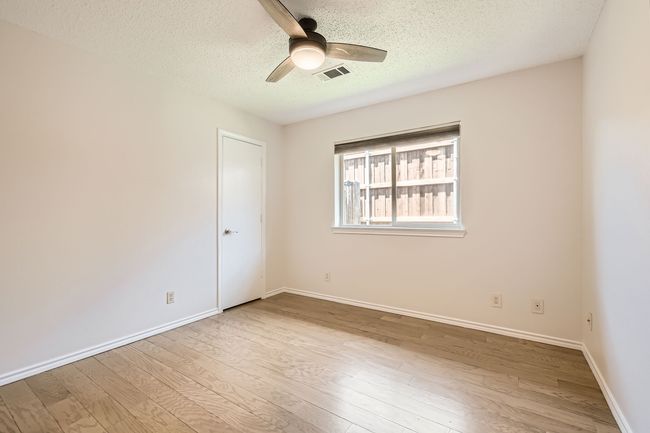 Bedroom featuring wood finished laminate floors, a ceiling fan, and a textured ceiling | Image 18