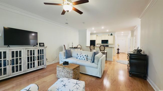 Living room with crown molding, ceiling fan, light wood-style flooring, and recessed lighting | Image 24
