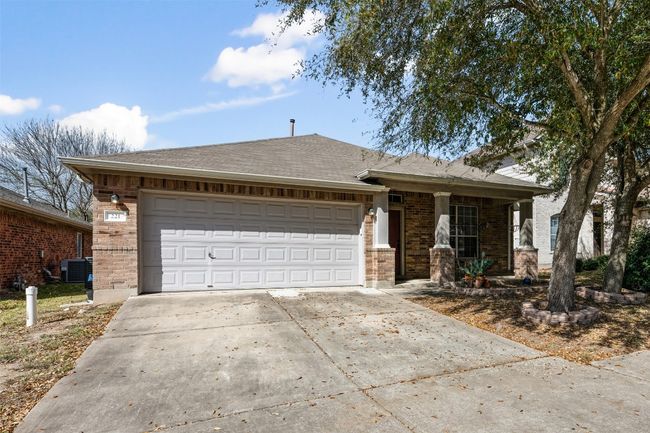 Ranch-style home featuring central air condition unit, brick siding, a garage, and driveway | Image 5