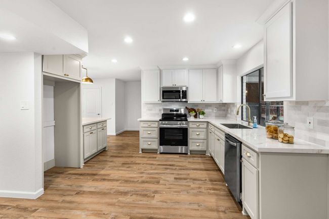Kitchen featuring appliances with stainless steel finishes, Zellige tile backsplash, and porcelain countertops | Image 9