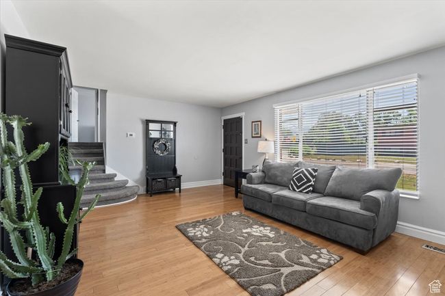 Living room featuring, wood finished floors, and stairway | Image 6