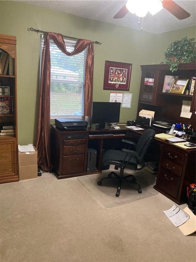 Carpeted home office with a textured ceiling and ceiling fan | Image 6