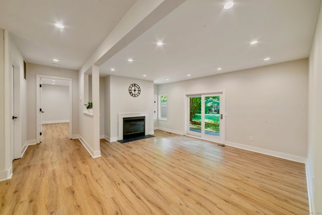 The sunken living room features a wood burning fireplace and sliders to the back patio. | Image 11