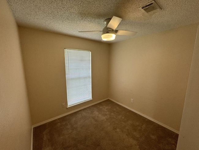 Carpeted bedroom room featuring ceiling fan and a textured ceiling | Image 18
