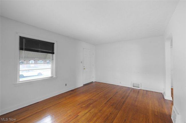 living room featuring baseboards, visible vents, wood finished floors, and arched walkways | Image 11