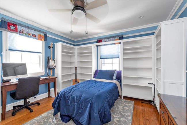 Bedroom with a ceiling fan, wood finished floors, and crown molding | Image 10