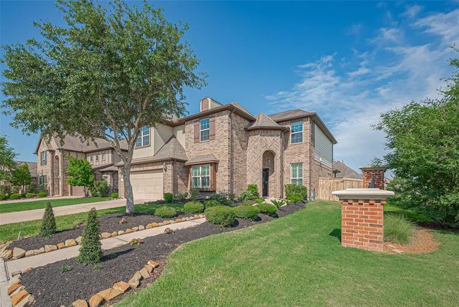 The house has a two-car garage and a welcoming entrance. It's set in a well-maintained neighborhood with similar homes. | Image 45