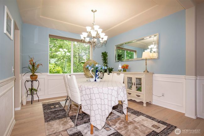 Dining Room with Wainscotting & Coffered Ceiling open to Living / Kitchen. | Image 8