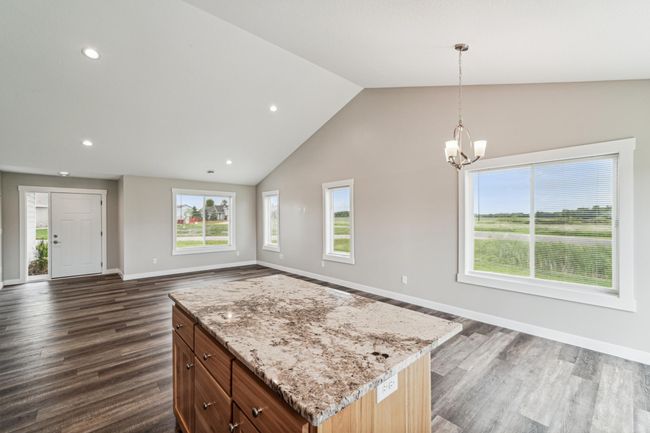 A center island with a granite countertop provides extra work space. | Image 11
