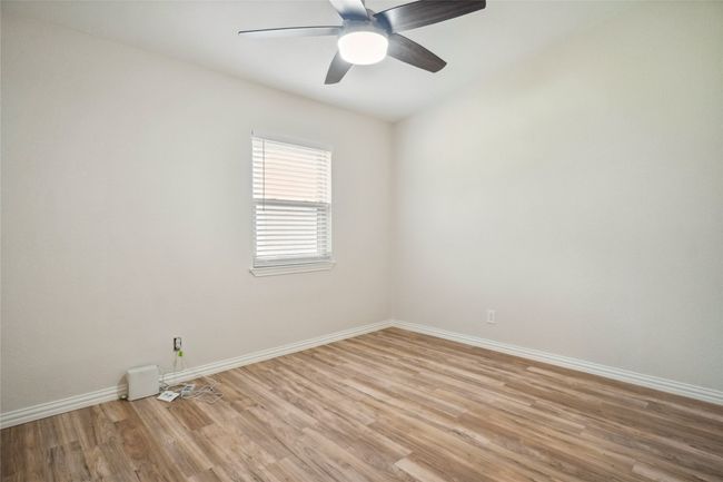 Bedroom with light wood finished floors, healthy amount of natural light and a ceiling fan with remote | Image 15