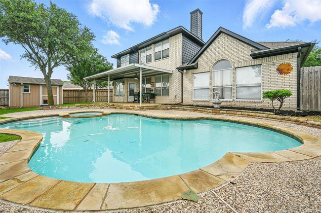 View of swimming pool with a patio area, a fenced backyard, a storage shed, and a pool with connected hot tub | Image 30